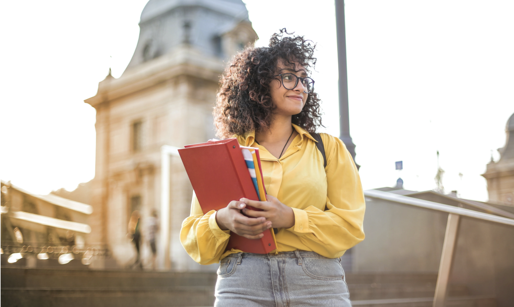 A woman holding a pile of binders