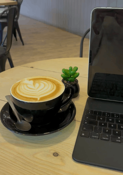 A latte coffee next to a laptop