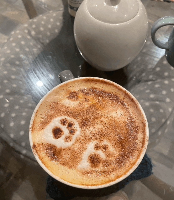A latte with paw print coffee art from Pause Cat Café
